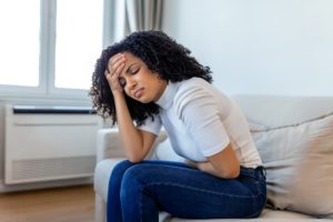 Woman with painful expression holds her stomach