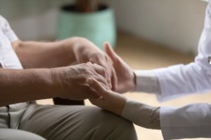 Close-up view of patient palms in the hands of supportive doctor