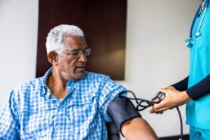 Nurse checking patient’s blood pressure with cuff