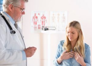 Seated patient talking with doctor while describing acid reflux symptoms 