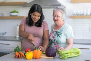 Two people at kitchen island chopping vegetables for diabetes-friendly meal