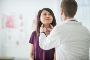 Female patient having thyroid checked out by doctor