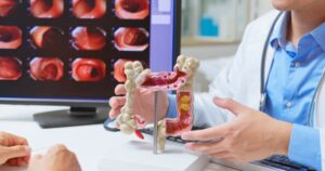 Gastroenterologist explains model of large intestine to patient