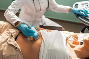 Doctor performing abdominal ultrasound on patient to check for liver disease