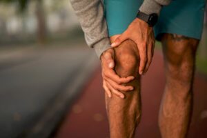 Runner on track grabbing knee
